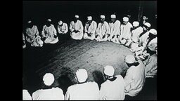 Mitglieder eines islamisch-religiösen Ordens sitzen in einem Kreis auf dem Boden  