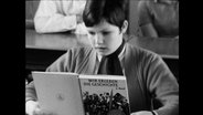 Ein Kind liest in einem Buch mit dem Titel "Wir erleben die Geschichte"  