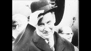 Porträt von Gerhard Schröder, der seinen Hut zieht  