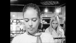 Porträt von zwei jungen Frauen, die in einem Kleidungsgeschäft bummeln  