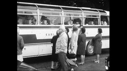 Eltern verabschieden Kinder vor einem Reisebus  