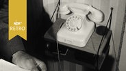 Ein Wähltelefon auf einem Telefontischchen 1963  