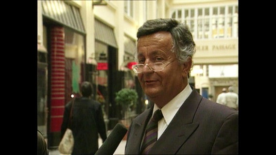 Jürgen Schneider spricht in ein Mikrofon.  