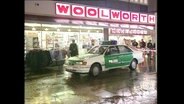 Ein Polizeiauto steht vor einer Woolworth-Filiale (Archivbild).  