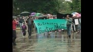 Teilnehmer eines Trauermarschs, die das Banner "Wir trauern und Guter Marx" halten.  