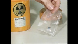 Eine Hand hält eine Plastiktüte mit illegal geschmuggeltem Plutonium.  