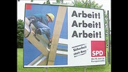 Ein SPD Wahlplakat mit der Aufschrift "Arbeit, Arbeit, Arbeit"  