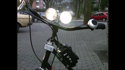 Ein Fahrradlenker mit leuchtendem Fahrradlicht  
