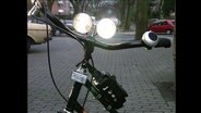 Ein Fahrradlenker mit leuchtendem Fahrradlicht  
