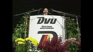 Mit Blumen geschmücktes Renderpult der rechtsextremen deutschen Volksunion  