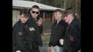 Fünf Skinheads mit schwarzen Jacken unterhalten sich (Archivbild).  