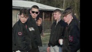 Fünf Skinheads mit schwarzen Jacken unterhalten sich (Archivbild).  