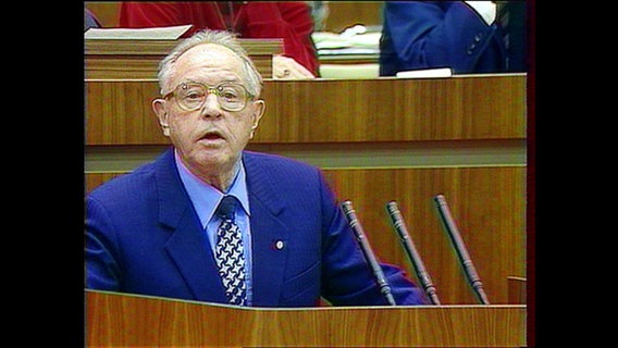 Mielke steht an einem Redepult.  