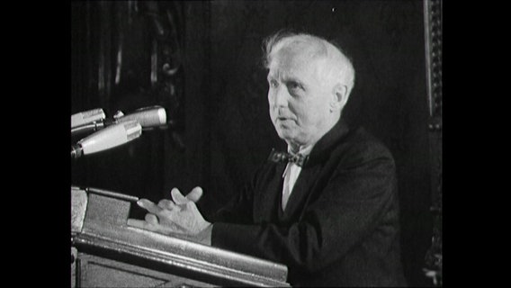 Max Ernst am Rednerpult bei Vortrag eines Gedichtes 1964  