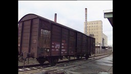 Ein Güterwagon steht auf einem Gleis.  