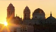 Blick auf die Türme und Kuppel der Kathedrale von Cádiz in der untergehenden Sonne. © NDR 