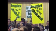Demonstranten halten Schilder hoch gegen "Giftmüllscheiß"  