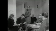 Mehrere Personen in einem Arztwartezimmer 1964  