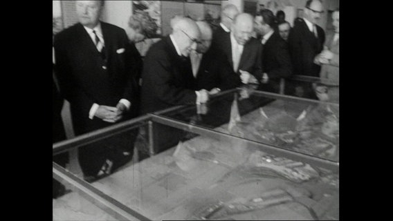 Interessierte ältere Männer neben Bürgermeister Edgar Engelhard beugen sich über eine Vitrine mit einem Hafenmodell (1964)  