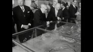 Interessierte ältere Männer neben Bürgermeister Edgar Engelhard beugen sich über eine Vitrine mit einem Hafenmodell (1964)  