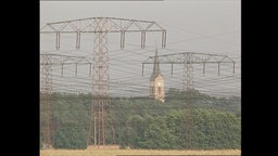 Strommasten stehen auf einem Feld.  
