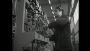 Arbeiter an einer Fabrik-Gussanlage für Plastikprodukte (1964)  