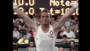 Ein Sportler hebt die Arme in die Luft (Archivbild).  