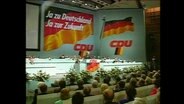 Einblick in einen CDU-Parteitag mit riesigen Werbetafeln  