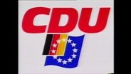 Der Schriftzug "CDU", darunter eine Deutschland- und Europaflagge (Archivbild).  