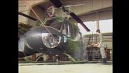 Ein Bundeswehr-Soldat reinigt einen Helikopter (Archivbild).  