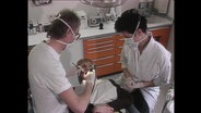 Ein Patient wird von einem Zahnarzt behandelt.  
