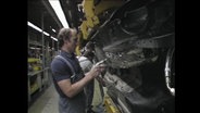 Ein Automechaniker arbeitet in einer Fabrik (Archivbild).  