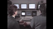 Zwei Männer sitzen vor einem Computer (Archivbild).  