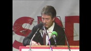 Der Politiker Björn Engholm steht spricht in Mikrofone, im Hintergrund ein SPD-Banner (Archivbild).  