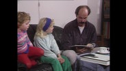 Ein Mann stellt zwei Kindern Fragen aus einem Fragebogen (Archivbild).  