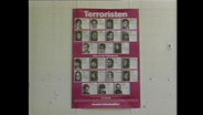 Ein Terroristen-Fahndungsplakat hängt an einer Wand (Archivbild).  