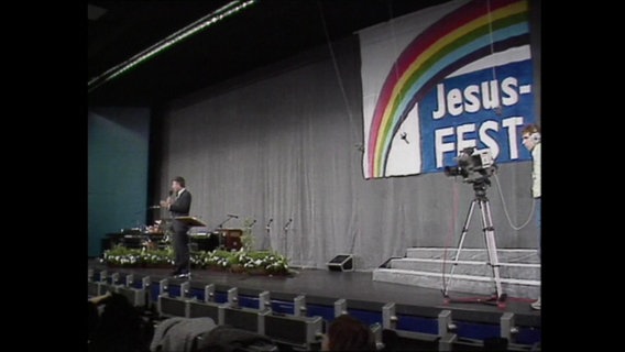 Eine Bühne mit dem Banner "Jesus-Fest", auf der eine Kamera steht (Archivbild).  