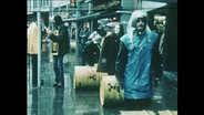 Demonstrierende rollen gelbe Fässer durch die Stadt (Archivbild).  