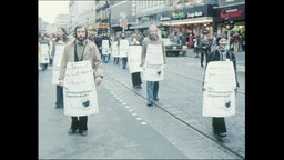 Demonstrierende tragen Schilder mit einem Steckbrief und dem Text "Als Verfassungsfeind amgestempelt" (Archivbild).  