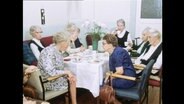 Seniorinnen und Senioren sitzen an einem Tisch (Archivbild).  