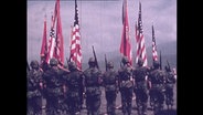 US-Soldaten stehen in Formation und tragen die US-Flagge (Archivbild).  