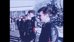 Männer in rechtsradikaler Uniform stehen in einer Reihe (Archivbild).  