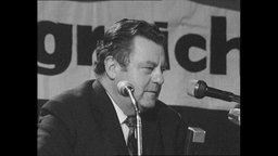 CSU Politiker Franz-Josef Strauß spircht an einem Podium  