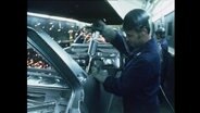 Ein Arbeiter schweizt an einem Auto in einem Opelwerk  