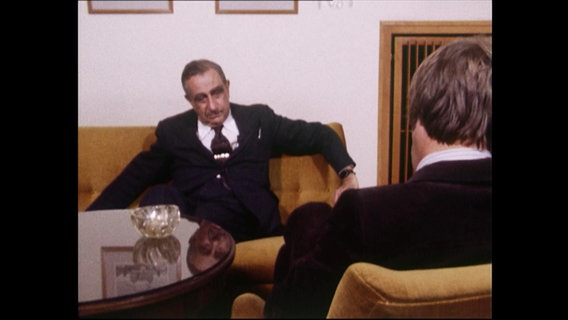 Ein Mann sitzt gemütlich auf dem Sofa  