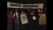 Eine Gruppe von Menschen hält ein Banner  