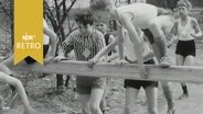 Kinder springen bei einem Hindernislauf bei Jugendsportveranstaltung in Wolfsburg über einen Balken (1965)  