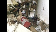 Flaschen mit Chemikalien liegen nach einer Explosion auf dem Boden  