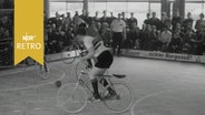 Radballspieler in Aktion in einer gut gefüllten Turnhalle (1965)  