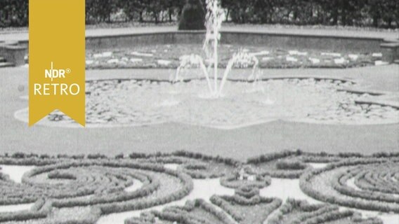 Springbrunenn hinter symmetrisch angelegten Beeten im Schlosspark Herrenhausen (1965)  